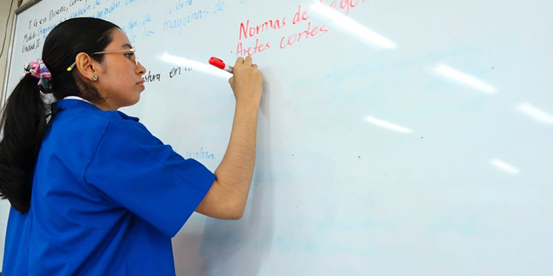 Docente en bata azul en clases en el Centro Tecnológico Hugo Chávez