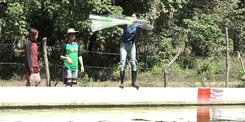 Mujer tirando la atarraya de pesca